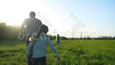 快乐的父母。 父亲正在花时间和两个孩子在一起。 女孩们和他爸爸在草地上奔跑。 触摸和奔跑